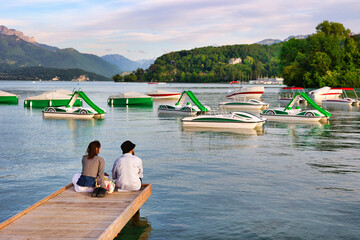 Un couple assis au bord du lac d'Annecy