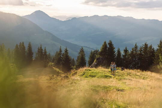 Two hikers walking through Kitzb&uuml;hel alpine landscape