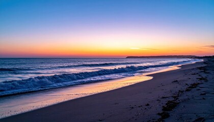 Obraz premium Beach sunset waves touch shore under colorful sky. Land in distance