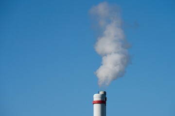 White smoke from the pipe against the blue sky.