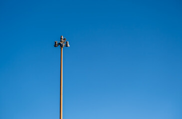 A tall pole with lanterns against the sky.