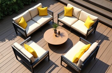 Furnished outdoor terrace with wooden composite decking boards. Modern patio furniture with beige sofas and yellow pillows. Round coffee table with plants. Sunny day light and shadow.
