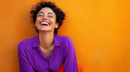 A young woman with curly black hair smiles widely, showcasing her joyful expression.