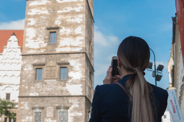 young woman with backpack taking selfie in the old town of Prague, Czech Republic