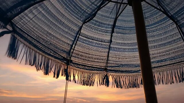 Sun shade on the beach. A classic fabric umbrella  against the evening sky by the sea.