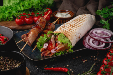 Appetizing grilled skewers with shawarma wrap stuffed with juicy meat, lettuce, cherry tomatoes and red onion. A perfect meal for food ads or menus
