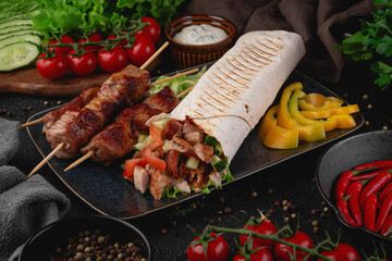Close-up of grilled pork skewers served with a stuffed shawarma wrap, fresh vegetables like cucumber and tomato, and yellow bell pepper slices. Perfect for restaurant menus and ads