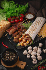 Delicious grilled meat skewers served with shawarma wrap stuffed with vegetables and cheese cubes. Garnished with mushrooms and fresh herbs, ideal for food promotions