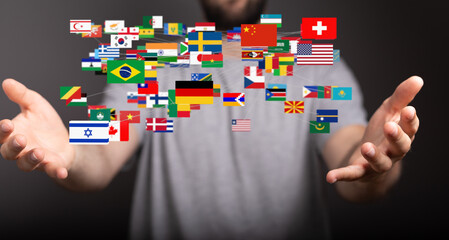 Image of person holding various national flags, symbolizing global connections and international...