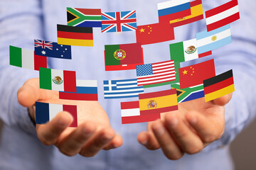 Image of hands gently cradling various national flags, symbolizing global connection and...