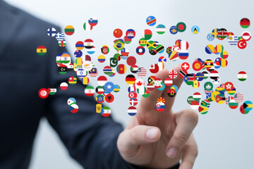 Image of a hand interacting with a digital display of world flags, representing global business and international connections.