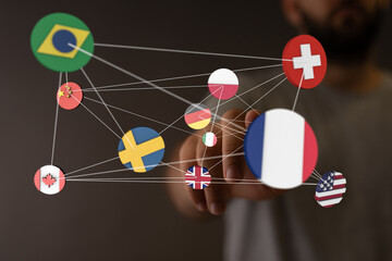 Image of a hand interacting with a network of flags, representing global collaboration and...