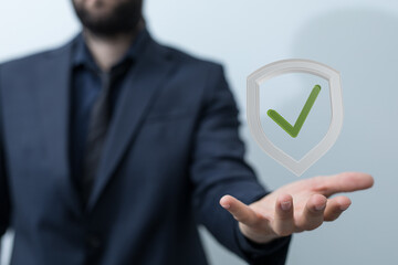 Image of a businessman holding a digital shield with a check mark, symbolizing security,...