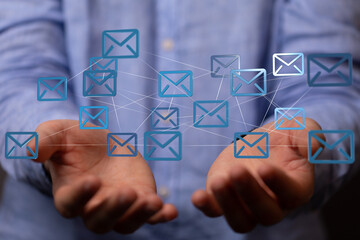Image of a man's hands holding a network of email icons, representing global communication and...