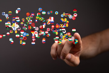 Image of a hand interacting with a digital display of world flags, symbolizing global connection and communication.