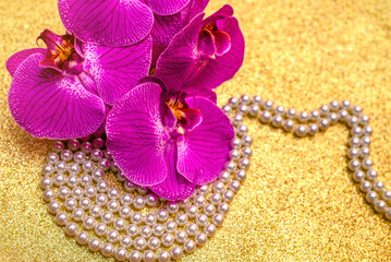 A branch of purple orchids on a shiny gold background
