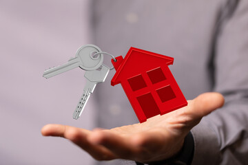 Hand holding house keys,home buying, selling, real estate concept.