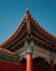 Ancient Chinese building's eaves and gables aerial view with colorful roof patterns and red pillar, contrasting blue sky and green architecture highlighting symmetry