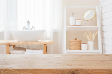 Empty wooden texture table top for product showing on blurred curtained bathroom window interior, sink and shelf