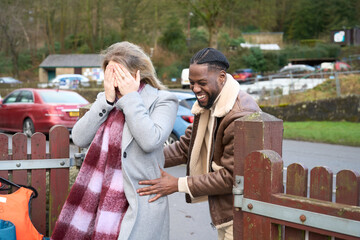 Smiling man with woman covering eyes outdoors