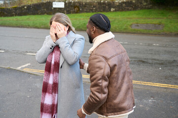 Smiling man with woman covering eyes on road