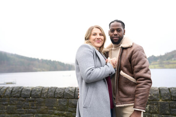 Portrait of smiling couple standing on lakeshore