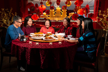 Smiling family enjoying Chinese New Year dinner in restaurant