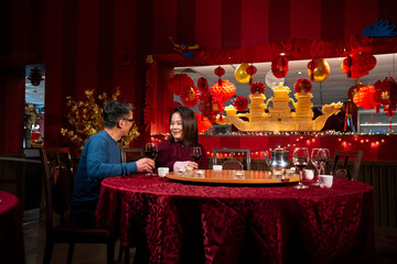 Smiling couple celebrating Chinese New Year in restaurant