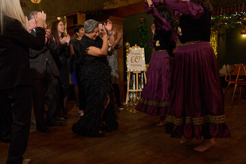 People attending dance show at 60th birthday party at nightclub