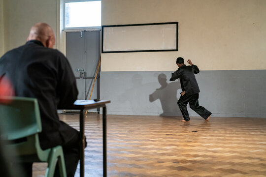 Man performing in front of coach during Kung Fu Black Belt test