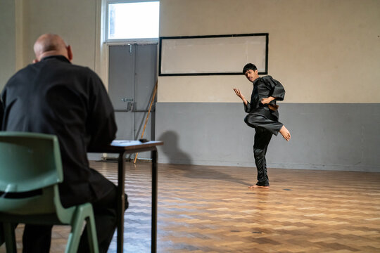 Man performing in front of coach during Kung Fu Black Belt test
