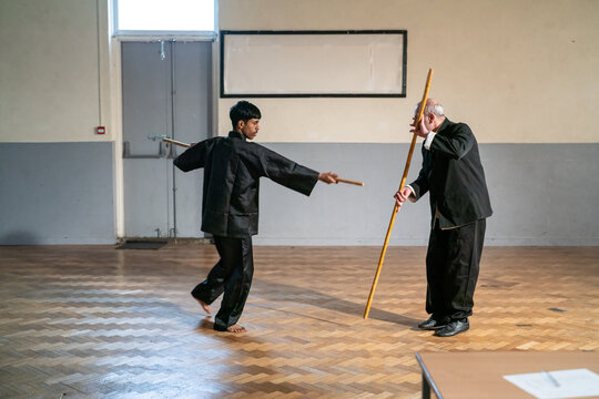 Man wit wooden stick undergoing Kung Fu Black Belt test