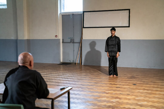 Man performing in front of coach during Kung Fu Black Belt test