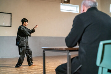 Man performing in front of coach during Kung Fu Black Belt test