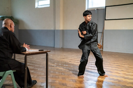 Man performing in front of coach during Kung Fu Black Belt test