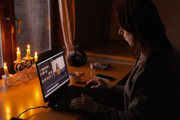 woman looking at laptop screen at table