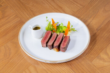 Medium Rare Wagyu Beef Steak with Sauce and Vegetables on White Plate