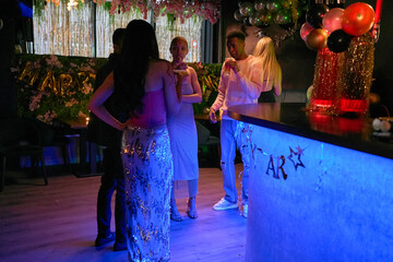 Friends enjoying cocktails at bar during New Years Eve party