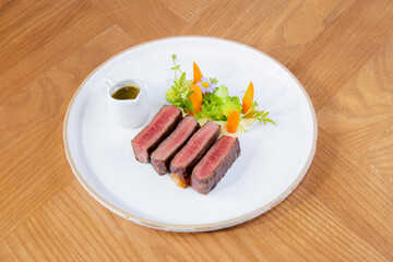 Medium Rare Wagyu Beef Steak with Sauce and Vegetables on White Plate
