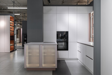 stylish modern built-in kitchen with upper and lower cabinets, drawers, shelves. kitchen facades are white and peach in color. Large, bright kitchen unit. Built-in kitchen appliances. white countertop