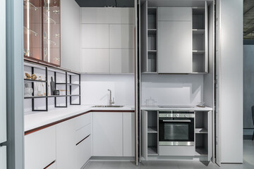 large modern built-in kitchen with lots of upper and lower cabinets, drawers and shelves. light...