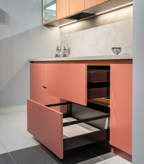 built-in peach-colored kitchen with beautiful facades. Kitchen with lower cabinets, countertop,...