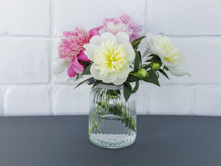 Beautiful bouquet of peony flowers in the glass vase.