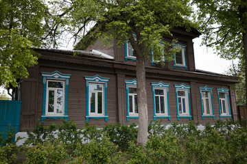 A house with a blue trim and a tree in front of it