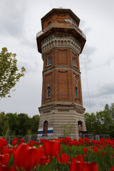 A tall brick tower with a red roof