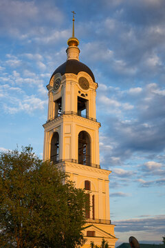 A tall white tower with a black top and a cross on top