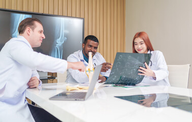 Obraz premium medical team discussing and review rare disease case to improve the practice guidelines,multiracial orthopedic doctors working in medical conference room