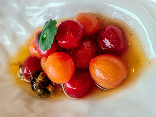 Close up of a cherry tomatoes and other veggies on a white plate background
