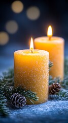 Two candles burning warmly, decorated with snow-dusted pine branches