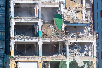 Urban demolition of high-rise building with exposed floors and rubble